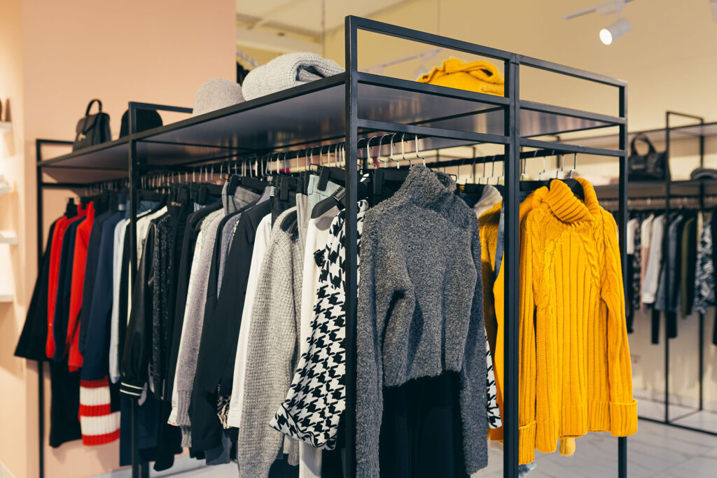 Fashion store. A number of different colorful women's clothes hanging on a shelf in the show room.